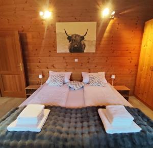 a bedroom with a large bed with a bull on the wall at Ferienhaus an der Drau in Sankt Oswald