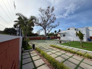 a walkway with palm trees and a white building at Vihaalaya stays in Tozhuppedu