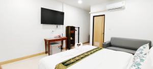 a hotel room with a bed and a television at DD Villa in Pathiu