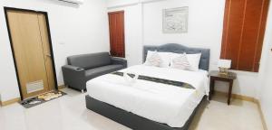 a bedroom with a bed and a chair at DD Villa in Pathiu