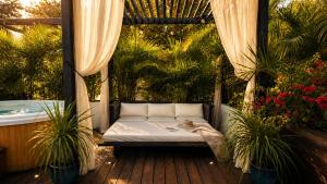 a porch with a bed and a bath tub at Résidence Nakiya in Sainte-Marie +46 photos