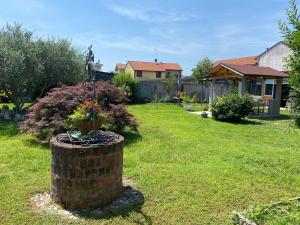 a garden with a brick pillar with a flower pot at La Magnolia in Magenta