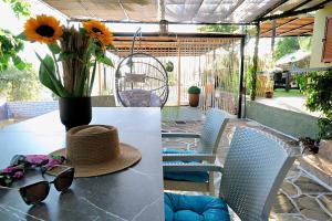 a table with a vase of flowers and a hat on it at Thassion-ikea Feels Like Home in Astris