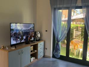 a living room with a flat screen tv and a window at Anno Zero Sweet House in Stazione di San Sostene