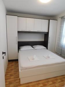 a bedroom with a bed with white cabinets at House Monika&Stela in Krvavica