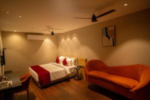 a hotel room with a bed and a chair at Hotel Vdara Bliss in Vijayawāda +10 photos