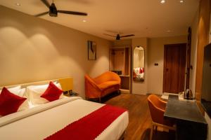 a bedroom with a bed and a desk and chairs at Hotel Vdara Bliss in Vijayawāda
