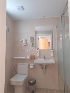 a bathroom with a toilet and a sink at Aparthotel ALMARIS in Es Pujols