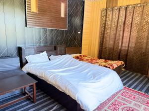 a hotel room with two beds and a table at Himalayan Stay in Sonāmarg +23 photos