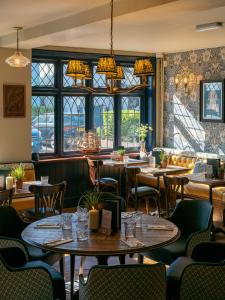 a restaurant with tables and chairs and windows at The Mayflower in Lymington