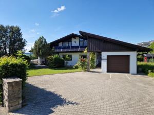 a house with a garage and a driveway at Ferienwohung Lederle in Weiler-Simmerberg