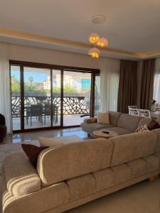 a living room with a large couch and a balcony at Villa Lost dalaman in Çakallık
