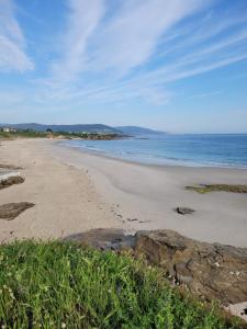 a sandy beach with the ocean in the background at Vaniria 4 Apartamentos Nuevos in Foz