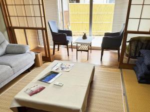 a living room with a couch and a table and chairs at おかげ参り宿場 in Ise