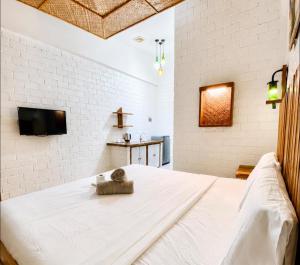 a bedroom with a white brick wall and a bed at Alona Marga in Panglao Island +4 photos