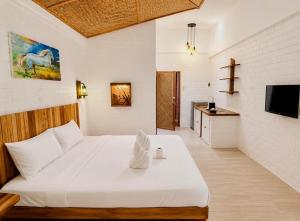 a large white bed in a room with a tv at Alona Marga in Panglao Island