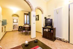 ein Wohnzimmer mit einem TV und einem Tisch in der Unterkunft HouSmart Palestro 5 in Bologna