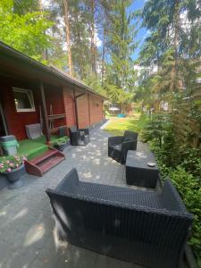a patio with black furniture and a house at DOMEK POD SOSNAMI in Krasnobród