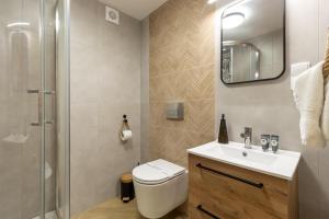 a bathroom with a toilet and a sink and a shower at Apartamenty Wiktorówka in Poronin +23 photos