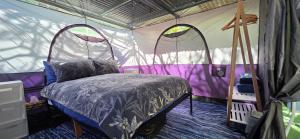 a bedroom with a bed in a tent at Meyenburg Glamping in Mount Morgan