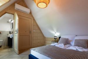a attic bedroom with a bed and a staircase at Apartamenty Wiktorówka in Poronin