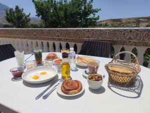 a table with breakfast food and drinks on a balcony at Bab Akchour in Chefchaouen