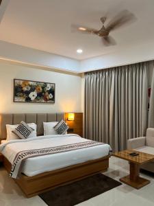 a bedroom with a large bed and a ceiling fan at Hotel Siddharth Grand in Varanasi +29 photos