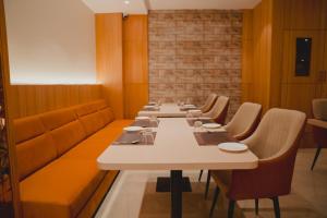 a long row of tables in a restaurant with chairs at Hotel Siddharth Grand in Varanasi