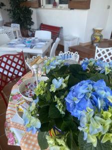 a table with blue flowers on top of it at Music House Palinuro in Palinuro