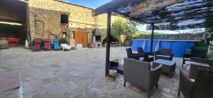 a patio with chairs and tables and a building at Can Manuel in Gabet