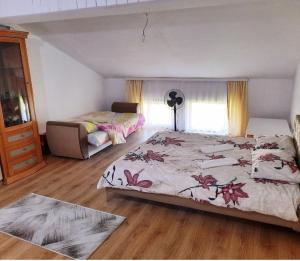 a bedroom with a large bed and a couch at Bus Station Hostel in Peje