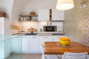a kitchen with a wooden table with a bowl of oranges at Casa Portosalvo, Modica in Modica +12 photos