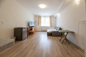 a living room with a bed and a desk in a room at Hotel Empire Europe in Prievidza