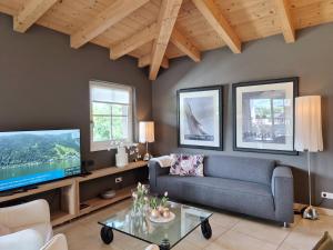 a living room with a couch and a tv at Peak View Penthouse Kaprun in Kaprun
