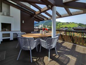 a wooden table and chairs on a deck with a view at Peak View Penthouse Kaprun in Kaprun