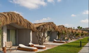 a row of chaise lounges and chairs outside a resort at LYV Boutique Cabana in Marsa Matruh