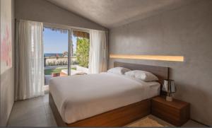 a bedroom with a large bed and a large window at LYV Boutique Cabana in Marsa Matruh