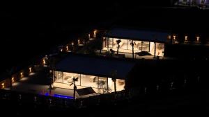 a building lit up at night with lights at Lakeside Palms in Tirana +39 photos