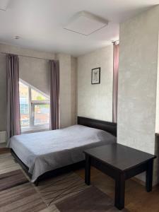 a bedroom with a bed and a coffee table at Apelsin apartment in Bila Tserkva