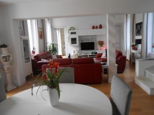 un soggiorno con divano rosso e tavolo di LE RELAIS DU BON'EURE a Évreux