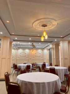 a banquet hall with white tables and chairs at HÔTEL Michou in Bafoussam