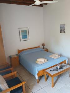 ein Schlafzimmer mit einem blauen Bett und einem Tisch in der Unterkunft Spanos House in Goudhi + 51 Fotos