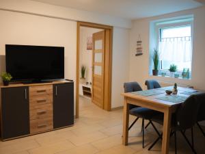 a living room with a table and a television at Ferienwohnung Carl in Weikersheim