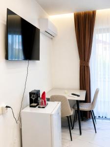 a living room with a table and a tv on the wall at Horizon Crown Rooms Ulcinj in Briska Gora