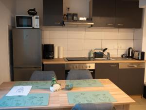 a kitchen with a wooden table with chairs and a counter top at Ferienwohnung Carl in Weikersheim +4 photos