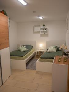 a bedroom with two beds and a table at Ferienwohnung Carl in Weikersheim