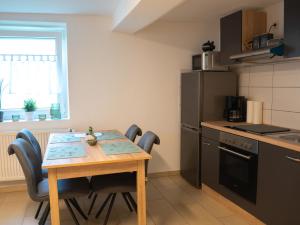 a kitchen with a table and chairs and a refrigerator at Ferienwohnung Carl in Weikersheim