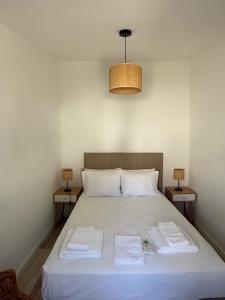 a bedroom with a bed with two towels on it at Casa do Pátio in Mértola