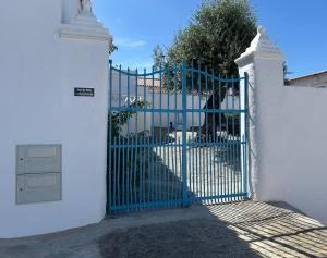 a blue gate in front of a white fence at Casa do Pátio in Mértola