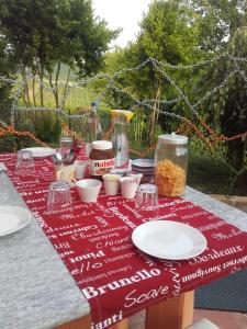 a table with a red table cloth with food on it at Cascina E&E in Costigliole dʼAsti
